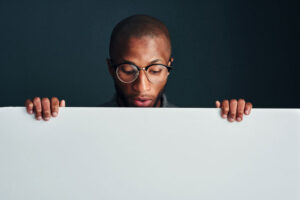 Man looking over white wall