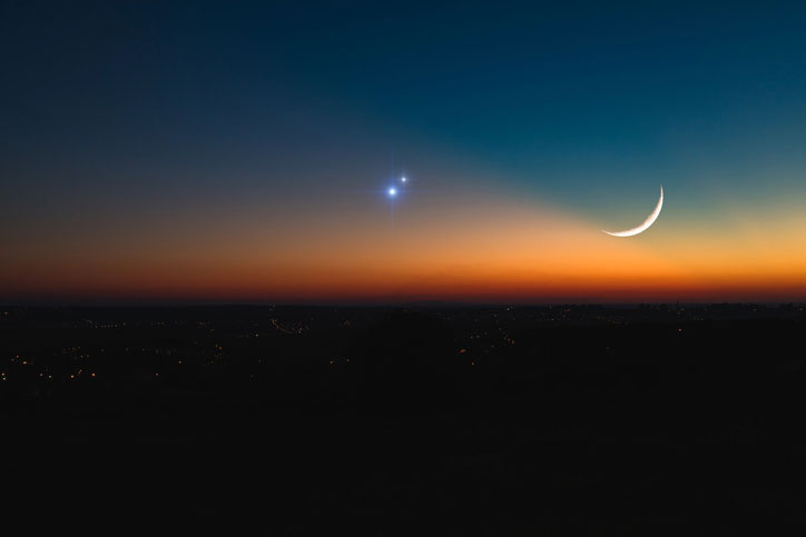 Night skyline with Jupiter, Saturn, and Earth's moon