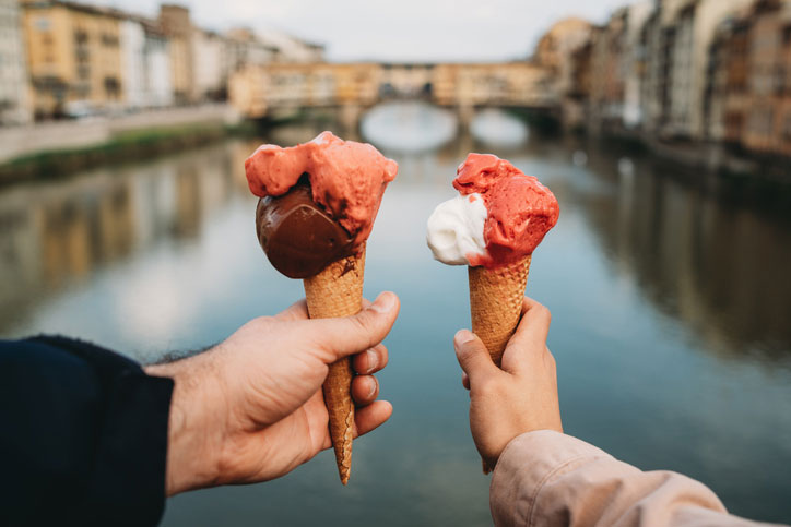 Couple having gelato in canals in Florence, Italy