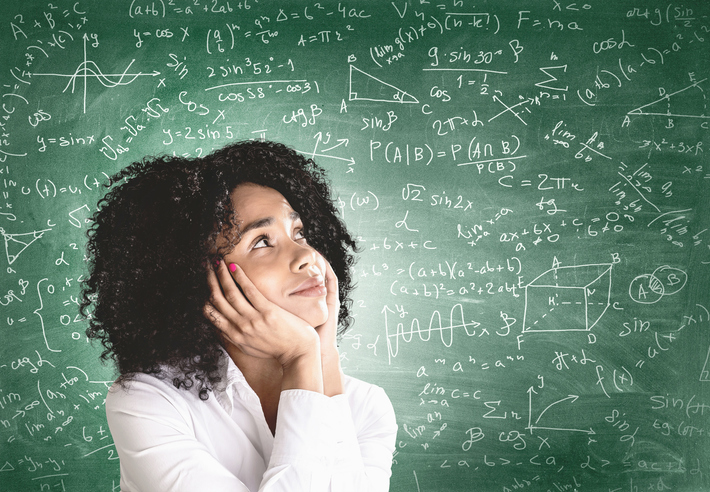 Math on chalkboard behind female student