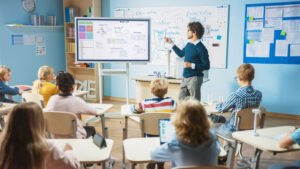 Teacher working on digital whiteboard in front of class