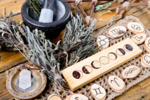 Botanicals, moon chart, and mortar and pestle on table