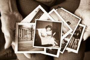 Elderly hands holding old historical photographs
