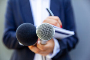 News conference speaking into microphones